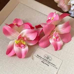 Gros plan de barrettes à fleurs d'orchidées en tissu rose pour accessoires de vacances