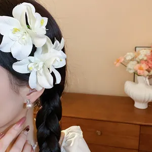 Gros plan sur d'élégantes pinces à fleurs de lys blanc sur une tresse de cheveux
