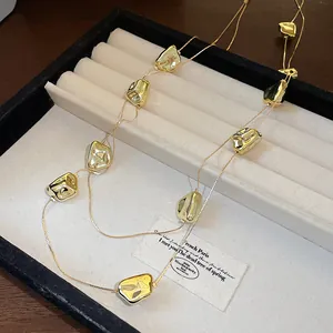 Gros plan détaillé d'un collier double couche doré froissé irrégulier dans un plateau bijoux.