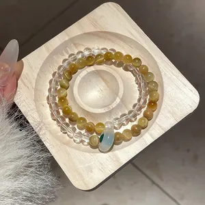 Close-up of golden tiger eye and clear crystal beaded bracelets on wooden display