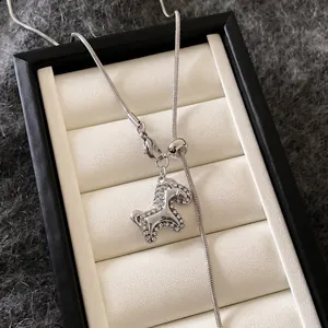 Dettaglio della collana a forma di cavallo in zircone argento con catena a serpente.