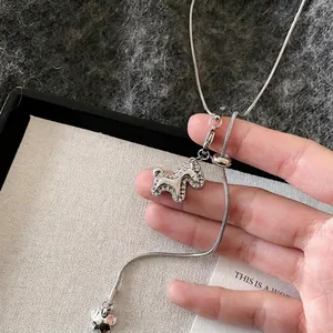 Primo piano del ciondolo a forma di pony argentato con zirconi e charm a fiore
