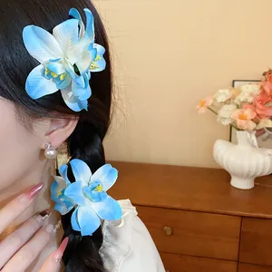 Gros plan de pinces à cheveux à fleurs en tissu bleu élégamment coiffées en tresse