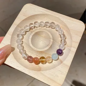 High-quality detail of clear quartz bracelet featuring tiger eye beads on a wooden tray