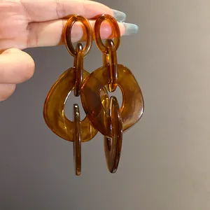 Detailed close-up of amber acrylic geometric earrings with warm translucent texture