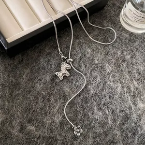 Dettaglio di un'elegante collana argento con pendenti cavallo e fiore in zirconia.