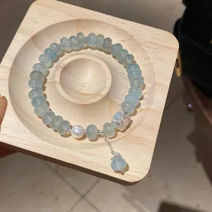 Detail view of elegant light blue crystal beaded bracelet with zircon flower and pearl accent