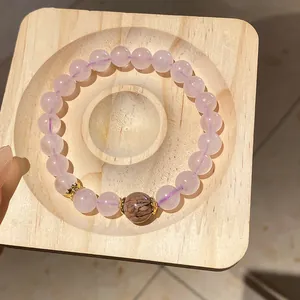 Close-up of a pink beaded bracelet with tiger eye stone and gold floral spacers