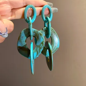 Detailed close-up showing turquoise and brown swirl pattern on acrylic geometric earrings