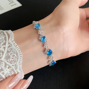 Close-up of an irregular silver bracelet featuring oval blue zirconia gemstones on a wrist