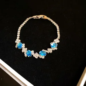 Detailed view of silver-toned bracelet with oval blue zircons and zigzag stones