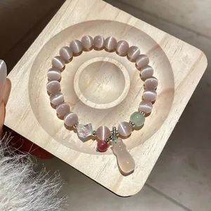 Elegant beaded crystal bracelet featuring purple cat's eye stones and a ghost charm