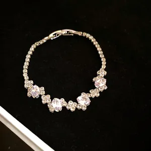 Close-up of an irregular zircon oval buckle bracelet on black velvet background