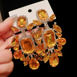 Detailed view of oversized vintage earrings with amber crystals and clear rhinestones