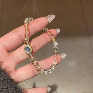 Detail of a retro citrine bracelet with blue center stone and gold hollow charms.