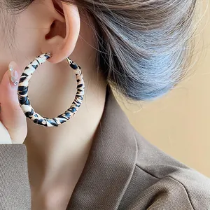 Detailed close-up view of stylish retro leopard print resin hoop earrings worn on a female ear