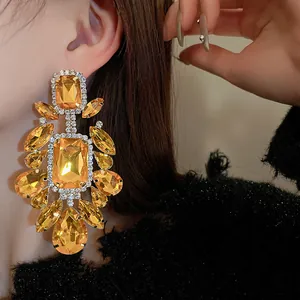 Close-up of oversized vintage earrings with amber crystals worn by an Asian model
