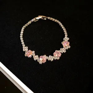 Close-up of pink oval zircons and clear stones on an elegant silver-toned bracelet