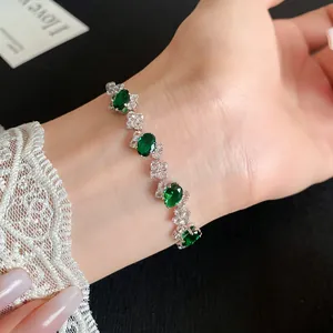 Detailed macro view of an elegant silver bracelet with oval green stones worn on a wrist