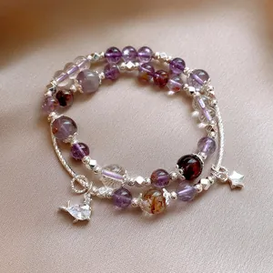 Macro detail of a luxury beaded bracelet with purple crystals and silver star charms