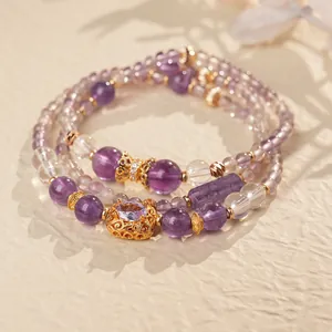Macro view of vintage multi-layer amethyst beaded bracelet with hollow golden flower