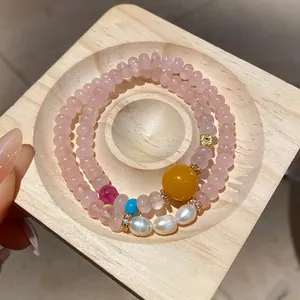 Detail view of pink rose quartz beaded bracelet with yellow tiger eye and white pearls