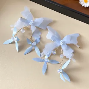 Detailed view of light blue fabric butterfly hair clip with crystal bead dangles.