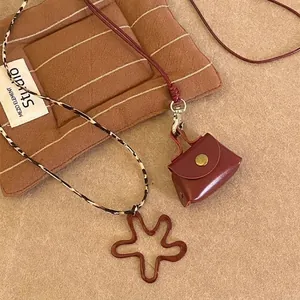 Luxurious geometric flower pendant necklace with a detailed mini leather bag accessory