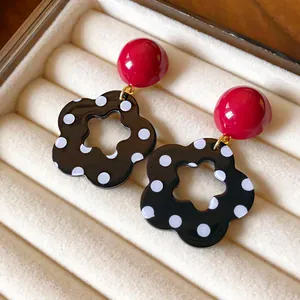 Retro black and white polka dot flower hollow earrings with red beads jewelry detail
