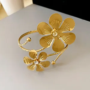 Vintage style gold cuff bracelet featuring two large engraved flowers with crystal centers