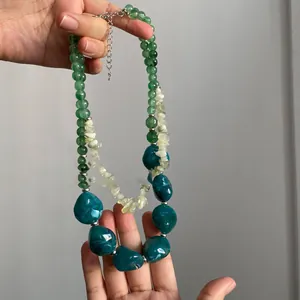 Détail du collier double rang avec perles vertes et pierres en acrylique bleu-vert foncé