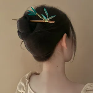 Detailed view of an elegant bamboo leaf wooden hairpin styled in a classic hair bun.