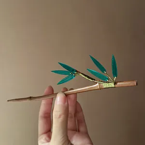 Close-up detail of a traditional Chinese-style bamboo hair stick with translucent green leaves