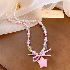 Close-up of a pink pearl necklace with an intricate beaded bow and star pendant