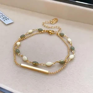 Detail view of French vintage double-layered bracelet with green beads and gold bar