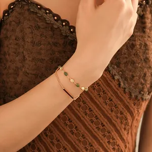 Detail view of French retro double-layer bracelet with green beads and gold bar