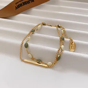 Detailed view of French vintage double-layer gold bracelet with green and white enamel beads