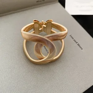 Gros plan montrant la texture en spirale complexe de ce bracelet vintage doré à double cercle