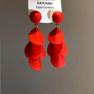 Makroansicht des mattroten Finishs und des mehrlagigen Quastendesigns dieser Ohrringe.