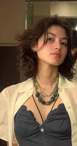 Détail d'un collier en acrylique à double rangée avec des pierres irrégulières vertes.