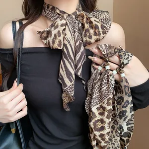 Detail view of stylish leopard and python print scarf necklace on model neck