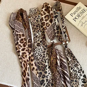 Close-up detail of animal print silk scarf necklaces with leopard and snake patterns.
