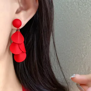 Nahaufnahme von matten roten Blütentanz-Ohrringen an Modell für elegante Details