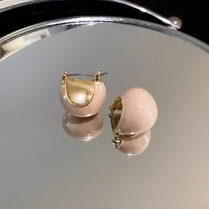 Detailed macro view of retro gold-plated bean hoop earrings with elegant nude enamel finish.