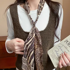 Close-up detail of a stylish leopard and snake print scarf necklace on a female model