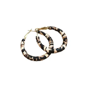 Retro leopard print woven hoop earrings with gold-tone hardware on white background