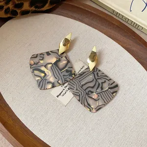 Close-up detail of vintage leopard print square earrings with elegant gold studs