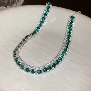 Close-up of elegant emerald square gemstone necklace with diamond-like pave setting.