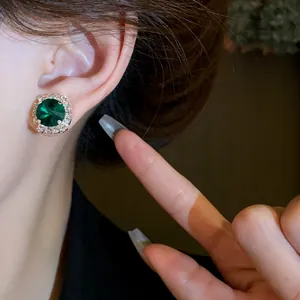 Close-up detail of an elegant emerald green halo earring with sparkling rhinestones