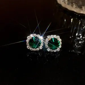 Detailed macro view of elegant square emerald stud earrings with a sparkling halo